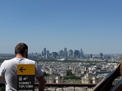 Man looking at a distant city skyline from above.